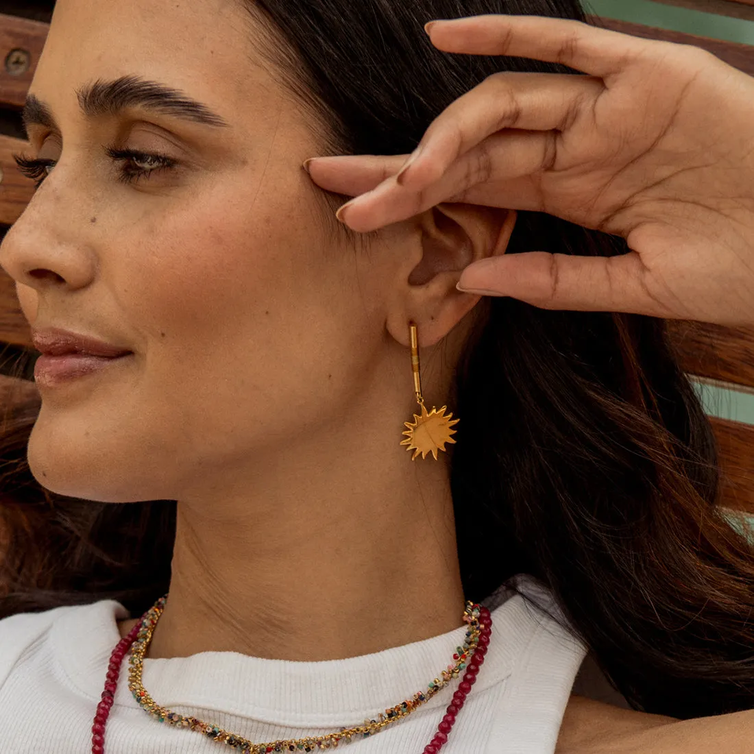 Bar earrings with woven threads and suspended sun charm